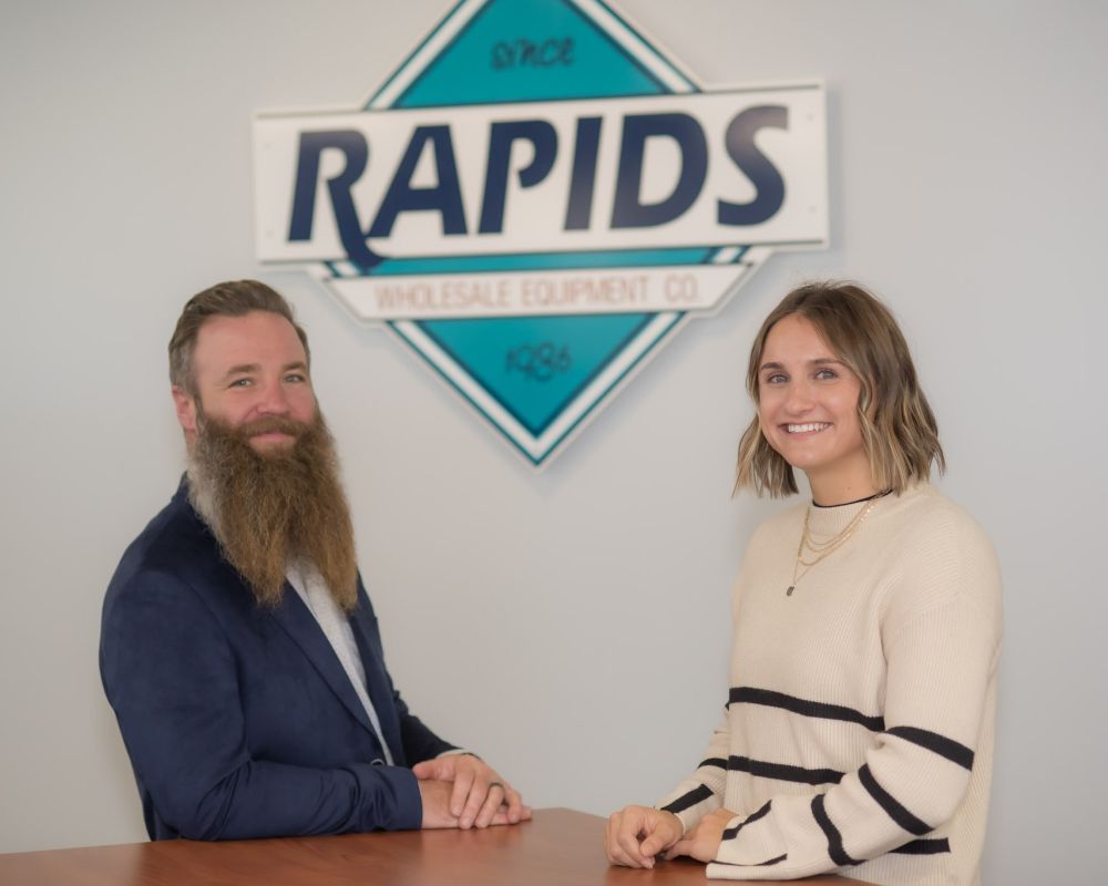 Luke Green & Mackenzie Beals in front of Rapids logo